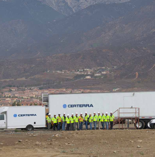 Certerra-branded vehicles and team members standing against a mountainous backdrop.