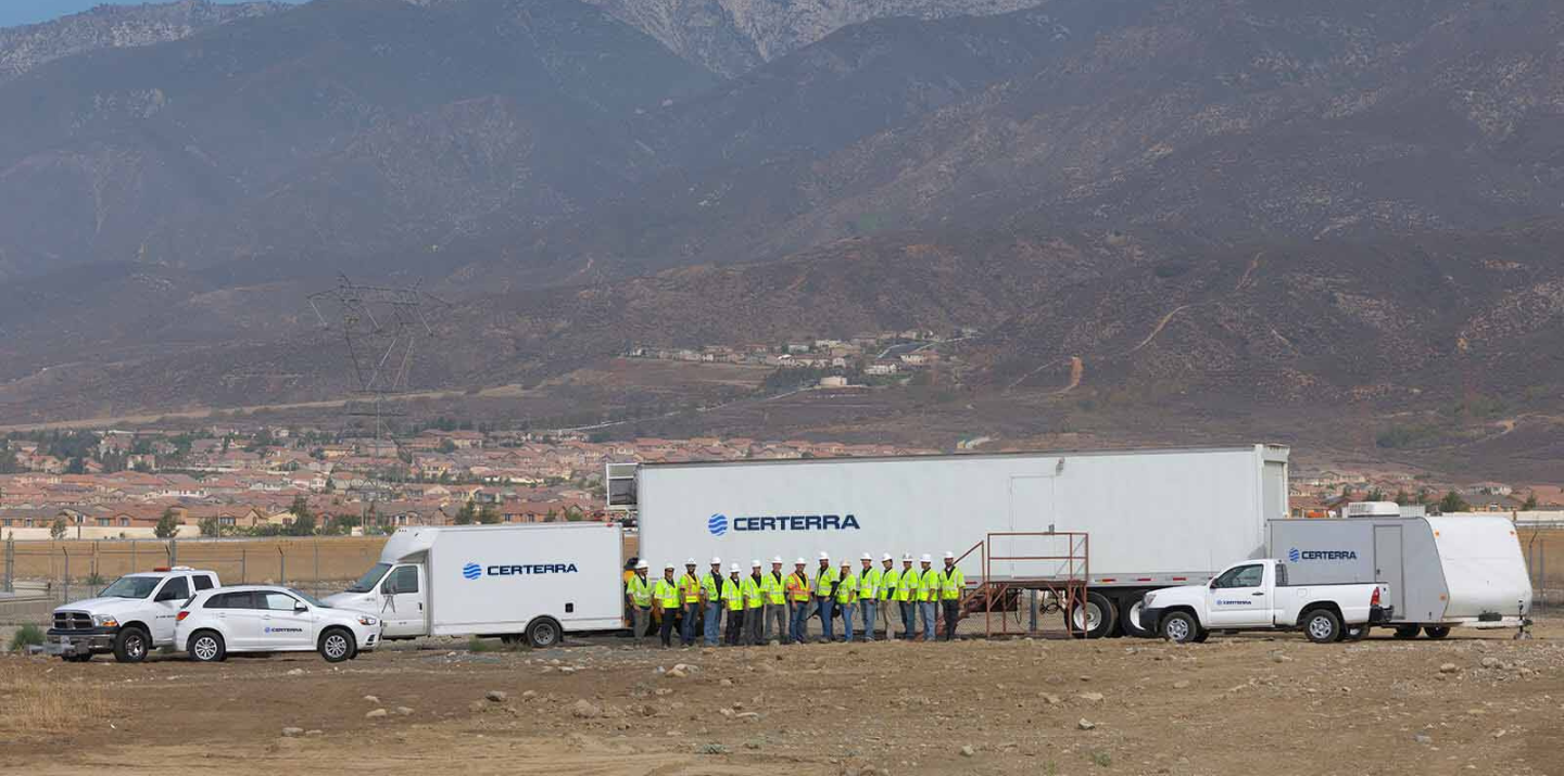 Certerra-branded vehicles and team members standing against a mountainous backdrop.